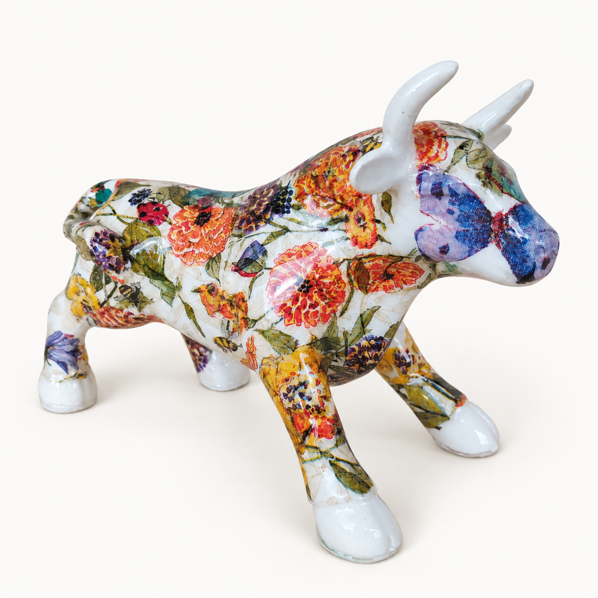 Torito en marmolina blanca con flores multicolores y mariposas, vista de tres cuartos