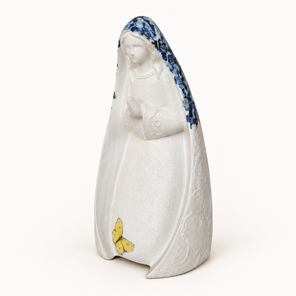 Virgen de 16 cm en marmolina con manto floral azul y mariposa amarilla, vista de tres cuartos